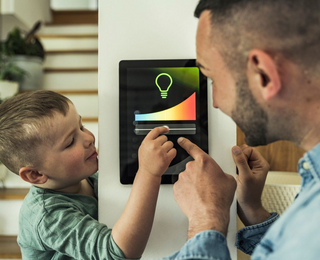 Vater und Sohn bedienen zuhause ein Smart-Home-Display