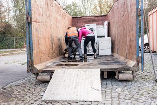 Mann und Frau laden Weiße Ware auf dem Wertstoffhof ab