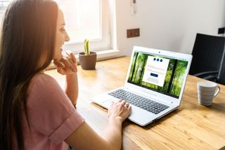 Frau sitz vor Laptop und hat die Seite des Erenja-Onlineservices geöffnet