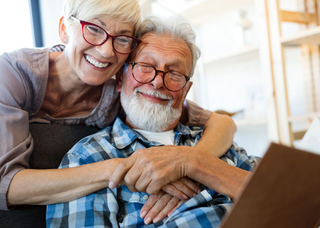 Älteres Paar schaut auf zufrieden Tablet