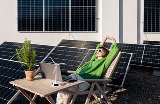 Frau im Liegestuhl umgeben von Photovoltaik