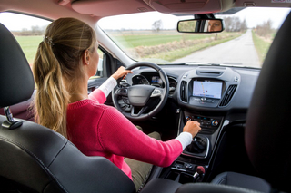 Blonde Frau im Auto schaltet