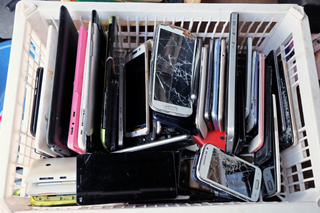 Symbolbild: Viele alte Handys in einem Plastikkorb