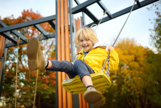 Junge schaukelt auf Spielplatz
