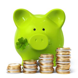 grünes Sparschwein mit Geldmünzen