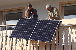 Zwei Männer montieren ein Solar-Balkonkraftwerk