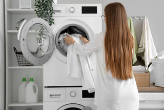 Frau füllt Waschmaschine